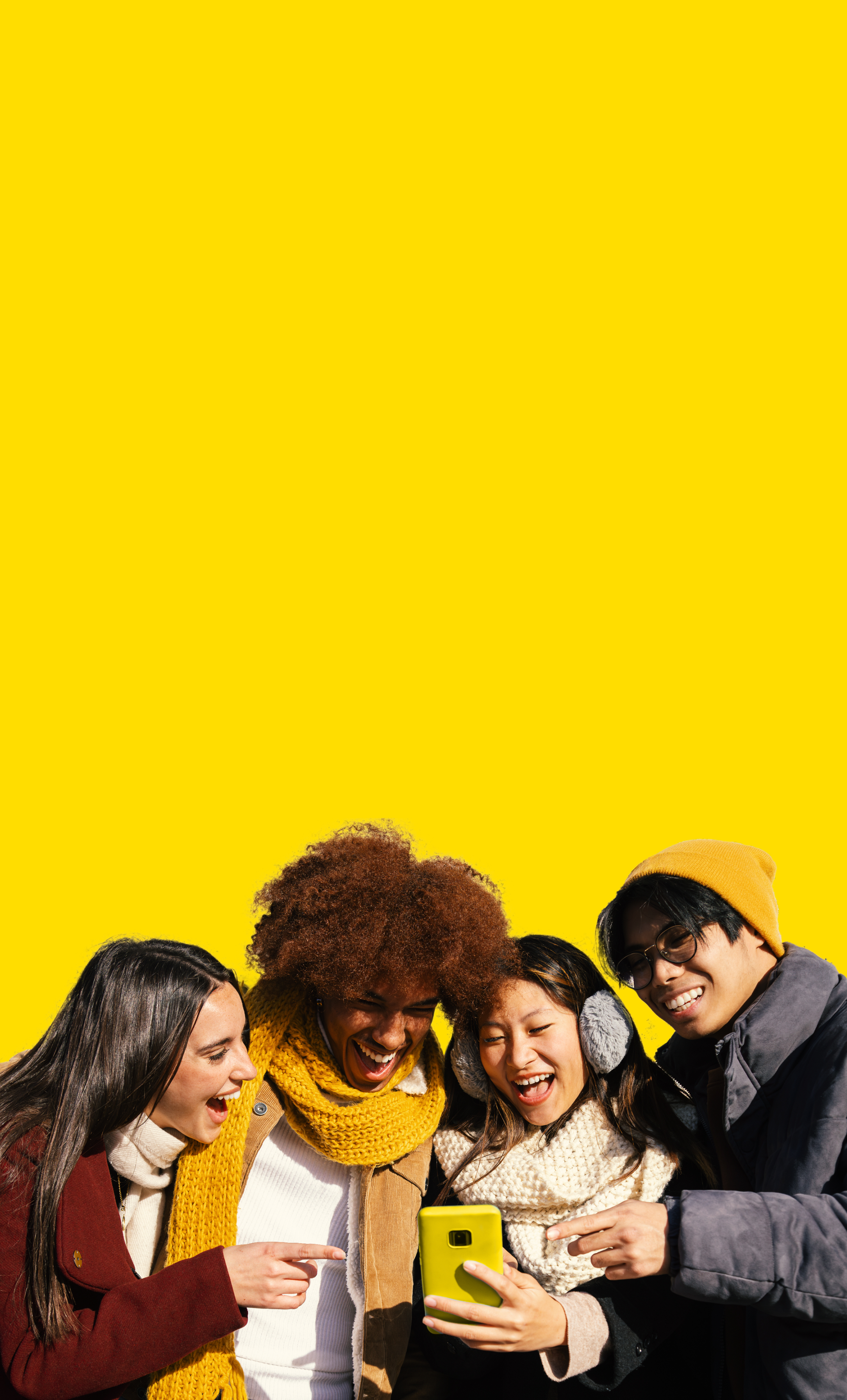 Eine Gruppe sitzen lächelnd nebeneinander und schauen auf ein Handy