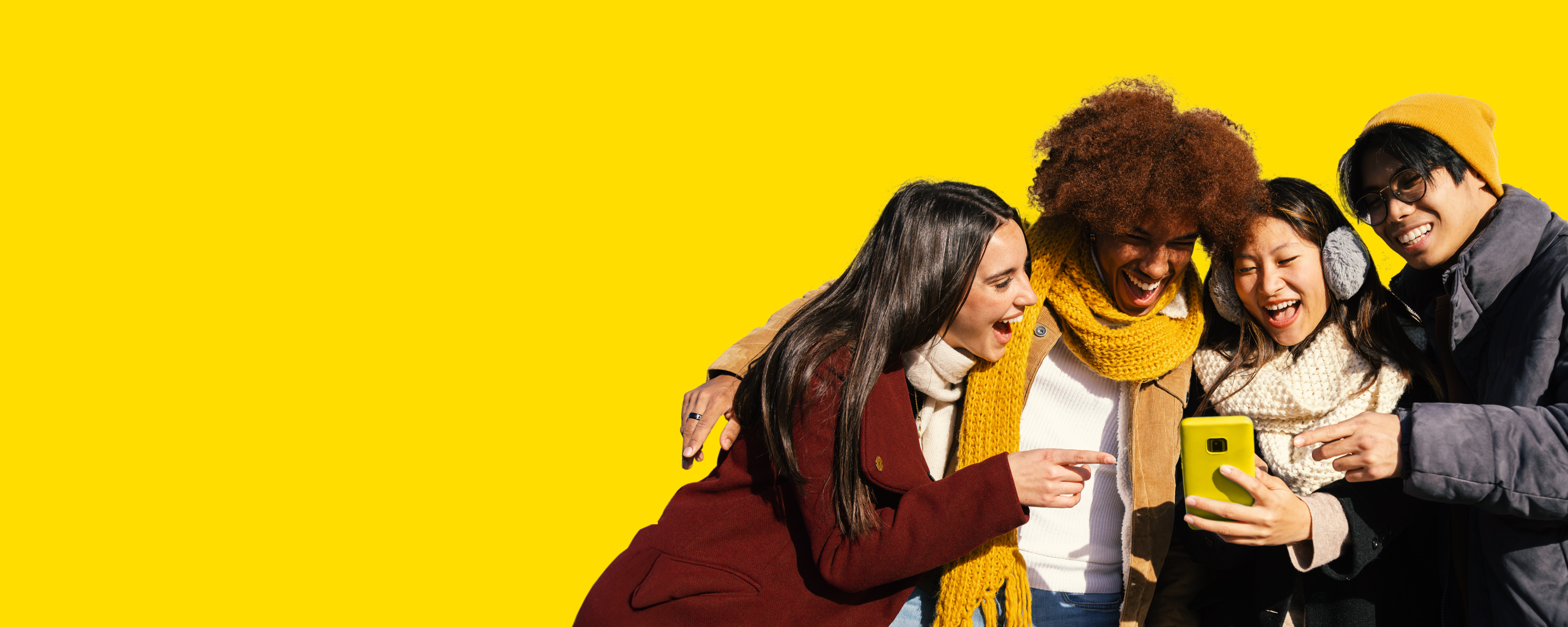 Eine Gruppe sitzen lächelnd nebeneinander und schauen auf ein Handy